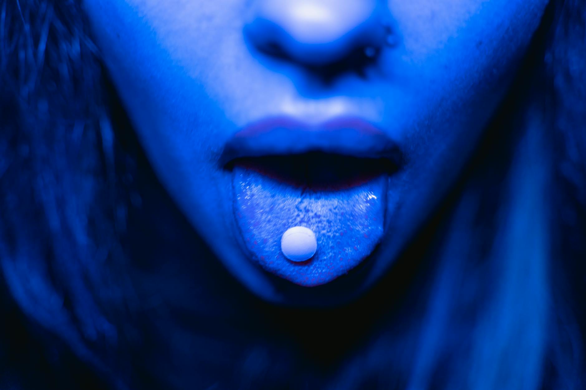 a drug tablet on a person mouth